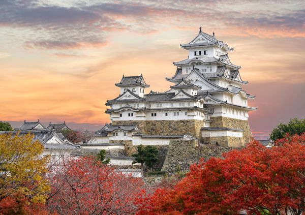 Lais Puzzle Burg Himeji und rote Ahornblätter im abendlichen Sonnenlicht und Dämmerungshimmel