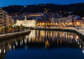 Lais Puzzle - Bilbao, Spanien. Luftaufnahme des Stadtzentrums von Bilbao, Spanien, mit dem Fluss Nervion und der Promenade bei Nacht. Spiegelung im Fluss - 1.000 Teile